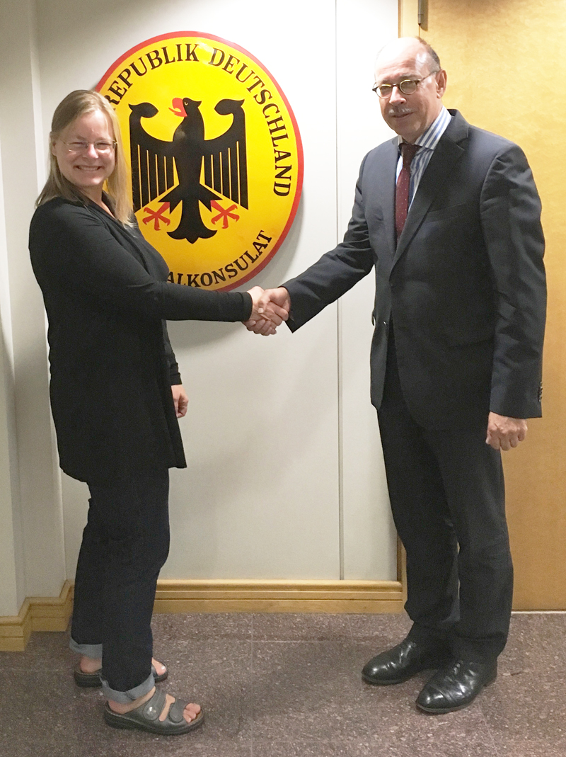 Elke shaking hands with Dr. Klaus Schmidt in front of the German Consulate in downtown Vancouver